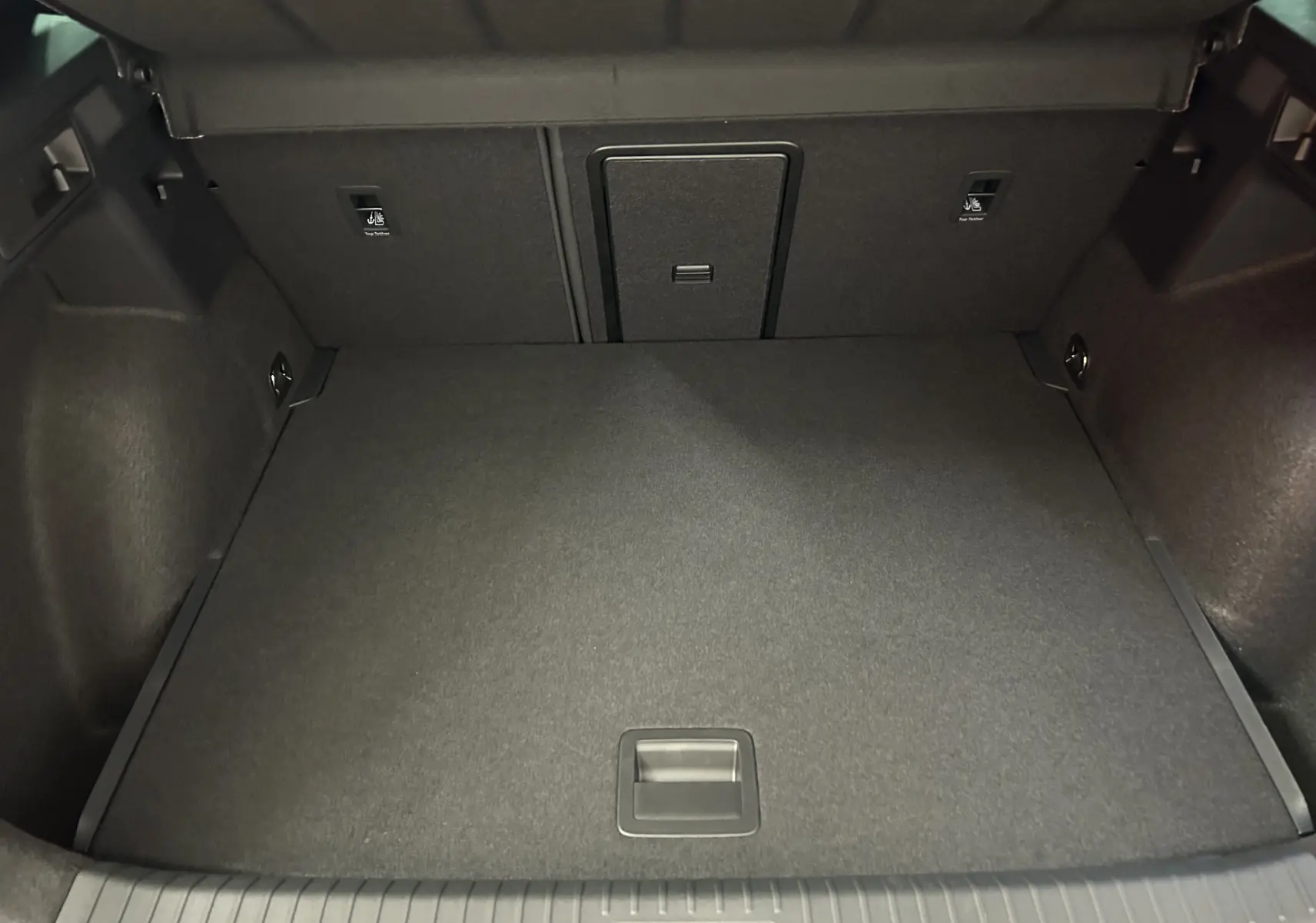 Coffre ouvert de la CUPRA Formentor 1.5 eTSI 150CH en vue intérieure, revêtement noir uniforme.