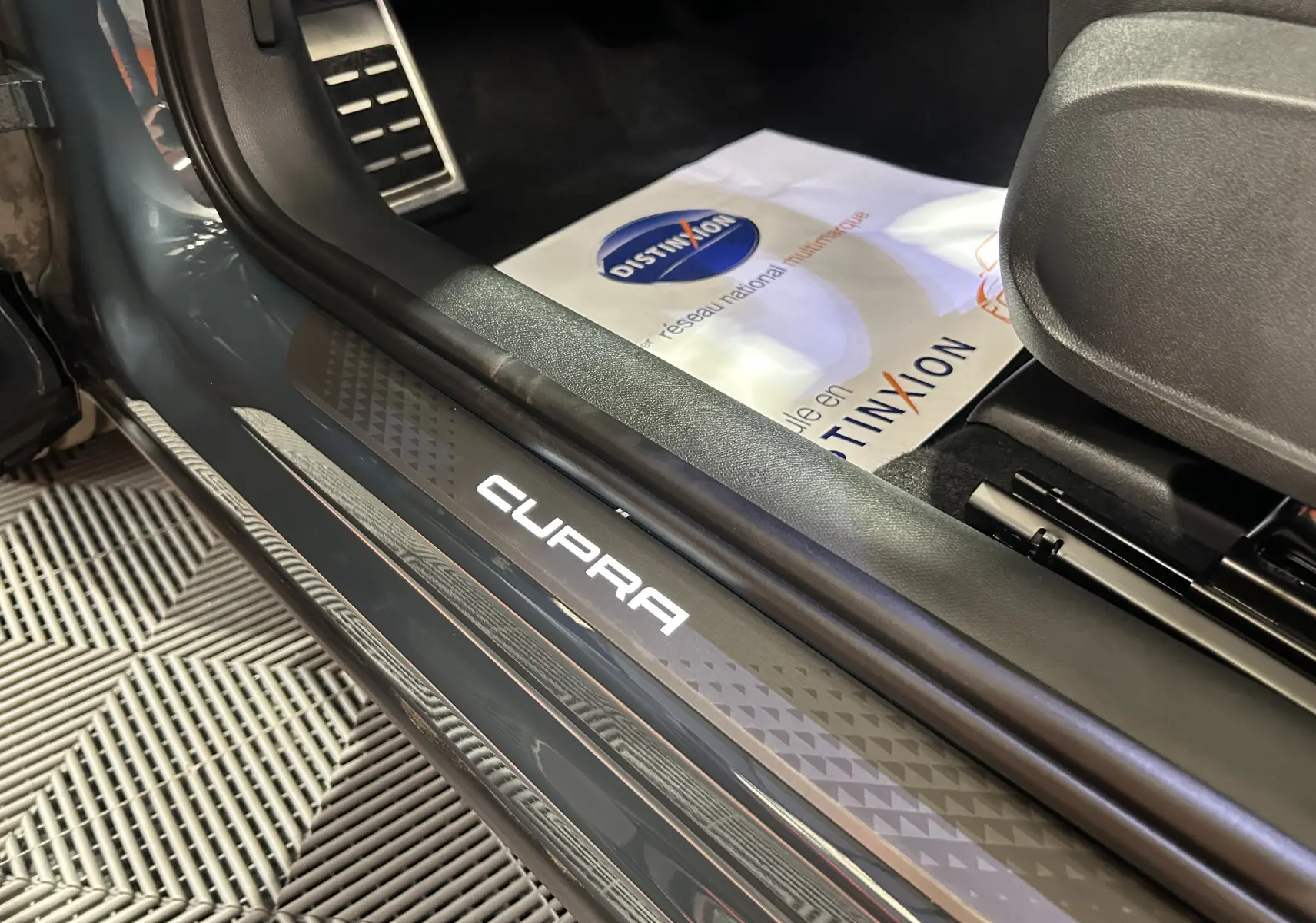 Gros plan sur le seuil de porte éclairé CUPRA à l'entrée côté conducteur d'un Formentor bleu Fjord Metal.