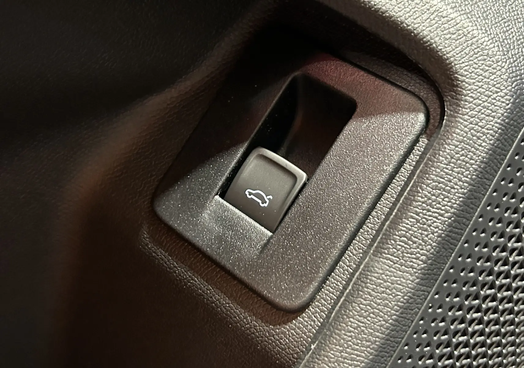 Bouton d'ouverture du hayon électrique sur la porte intérieure noire du CUPRA Formentor bleu Fjord 2026.