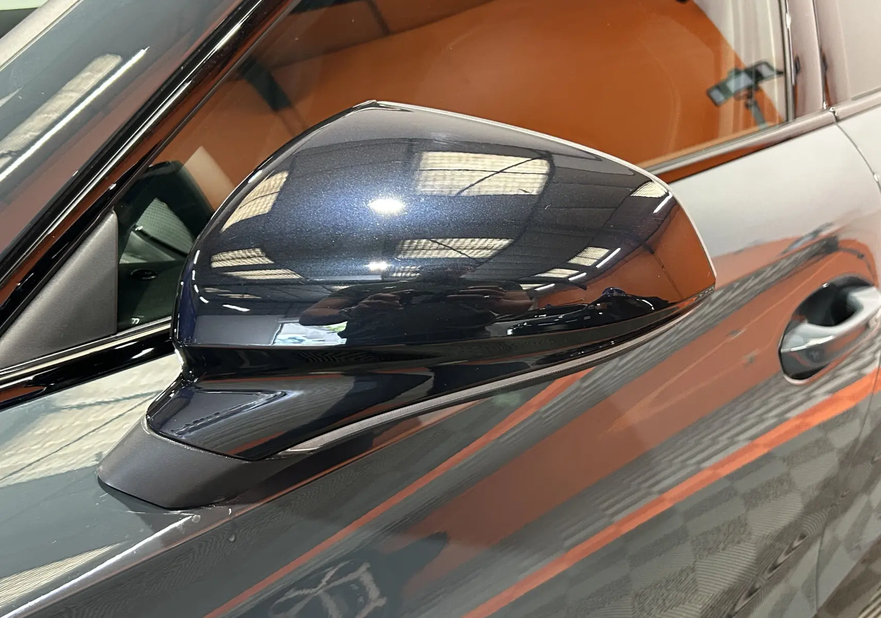 Rétroviseur côté gauche bleu fjord métallisé du Cupra Formentor 1.5 eTSI 2026 avec intérieur cuir marron visible.