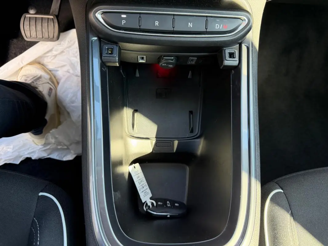 Vue plongeante sur la console centrale noire de la Fiat 600 T-Gen 3 blanche avec clé et sélecteur de boîte auto visible.
