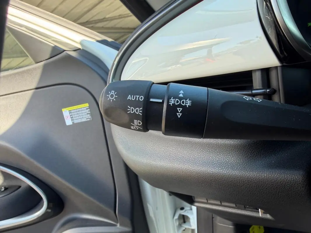 Détail du commodo d’éclairage dans l’habitacle d’une FIAT 600 blanc, côté gauche du tableau de bord.