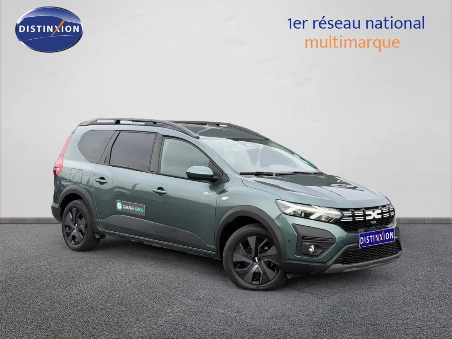 Dacia Jogger 2025 vert cèdre métallisé en 3/4 avant droit avec barres de toit et jantes noires.