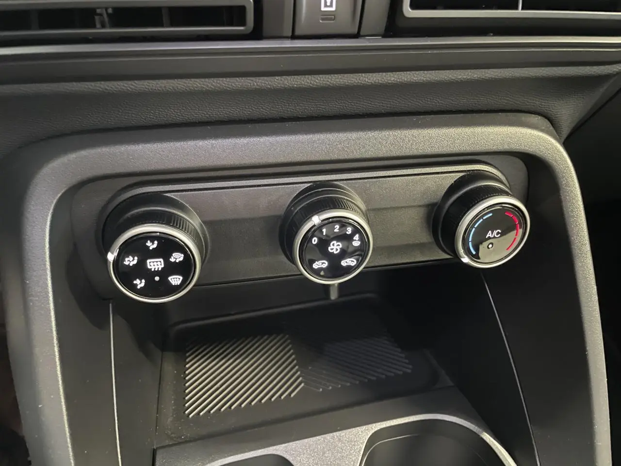 Vue rapprochée des commandes manuelles de climatisation noire dans l’habitacle de la Citroën C3 blanche 2025.