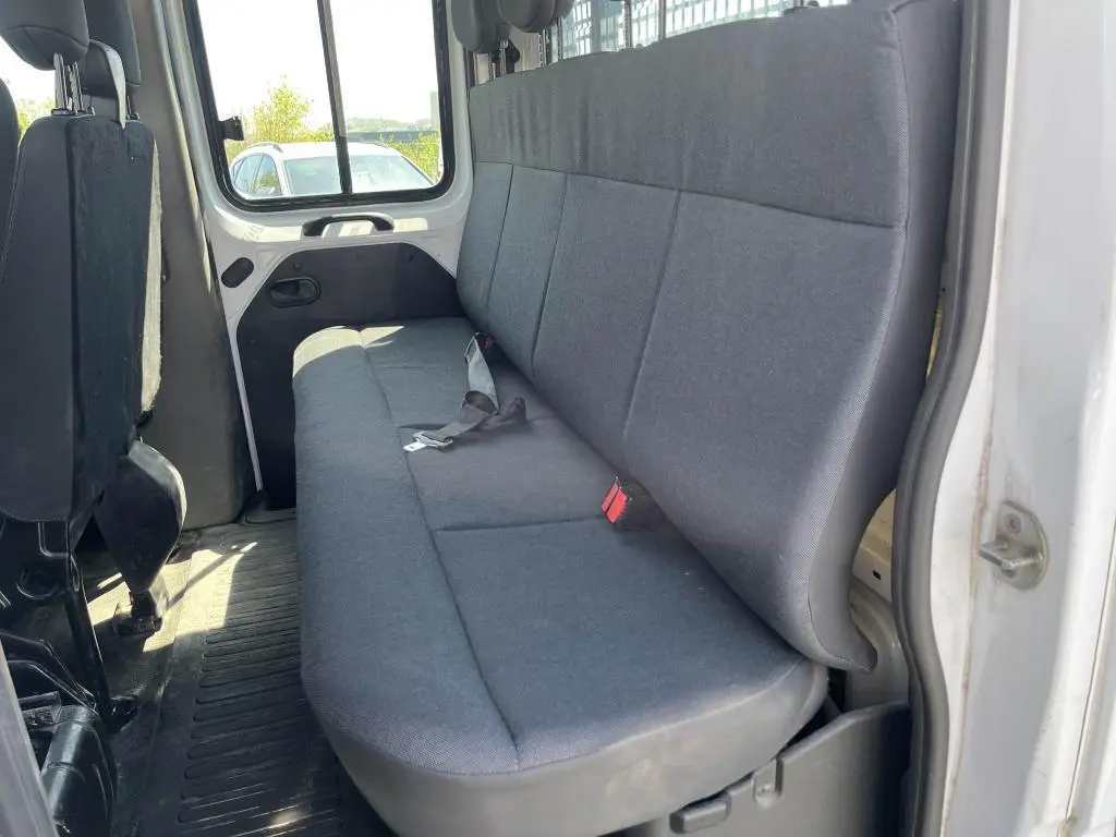 Vue intérieure côté droit sur la banquette arrière grise du Renault Master blanc double cabine avec ceintures visibles.