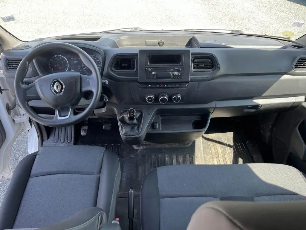 Intérieur du Renault Master 2020 vue de face, tableau de bord noir avec volant, levier de vitesses manuel et sièges tissu carbone.