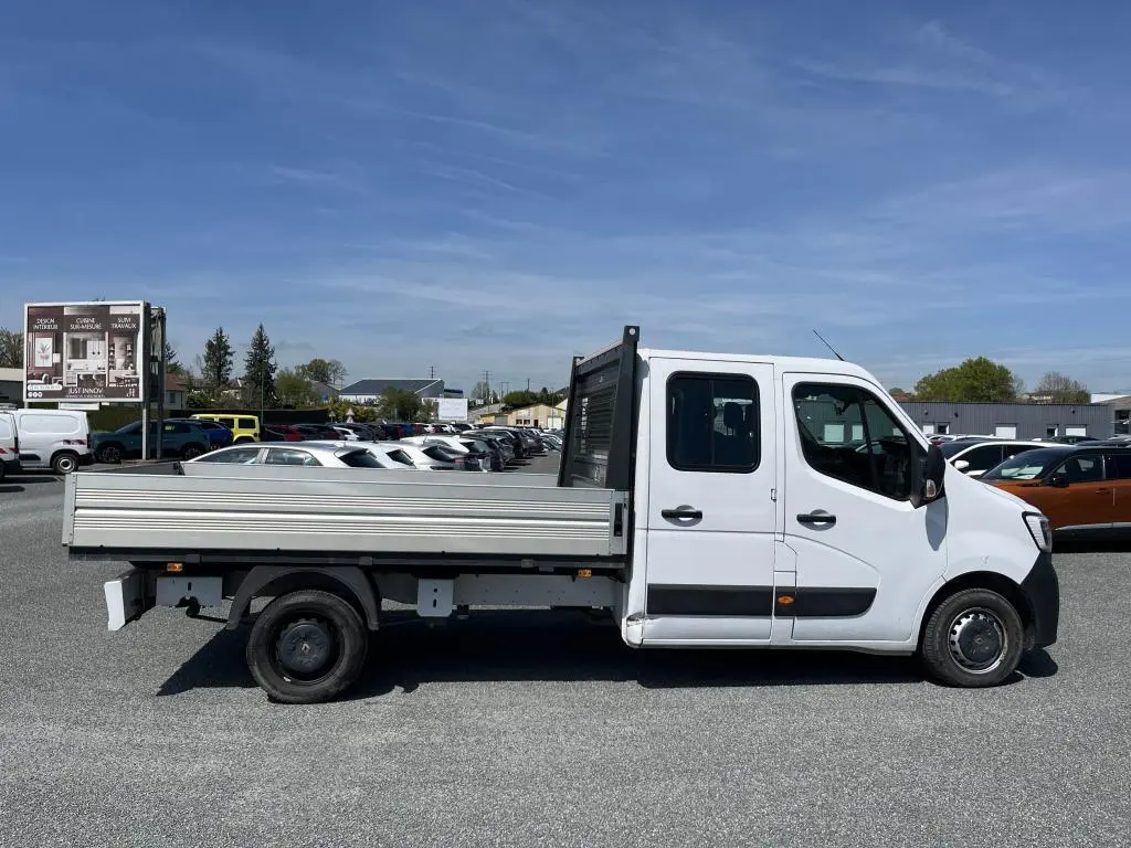 Profil droit d'un Renault Master blanc version Grand Confort double cabine avec plateau ridelles aluminium en extérieur.