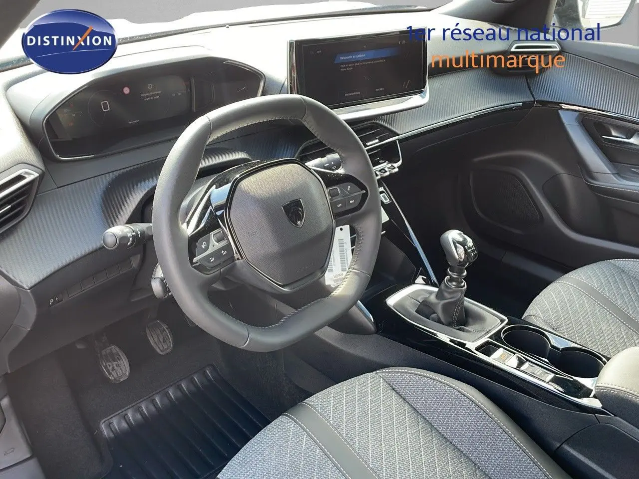 Intérieur du Peugeot 2008 2025 en gris, vue côté conducteur montrant volant compact, tableau de bord digital et levier de vitesse manuel.
