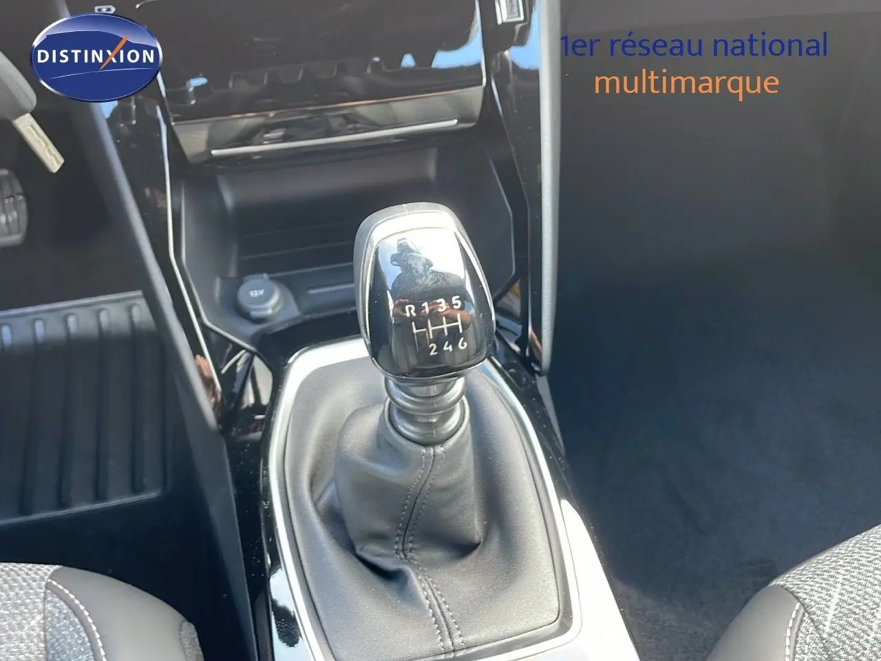 Le levier de vitesses manuel noir de la Peugeot 2008 2025, avec console brillante et sièges tissu gris.