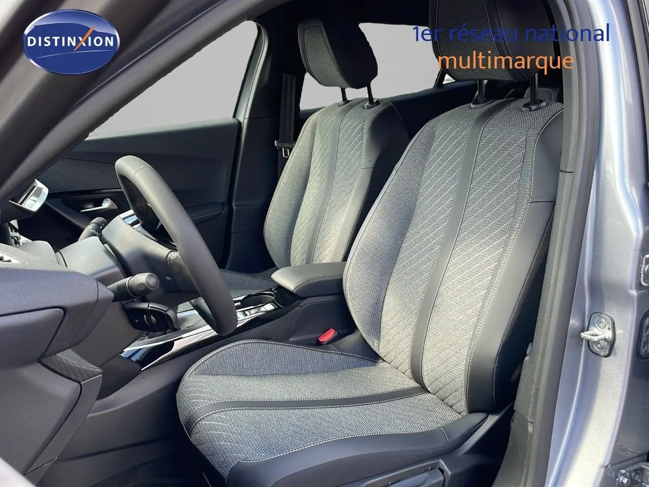Vue intérieure côté conducteur du Peugeot 2008 gris Artense, mettant en valeur les sièges en tissu et cuir noir.