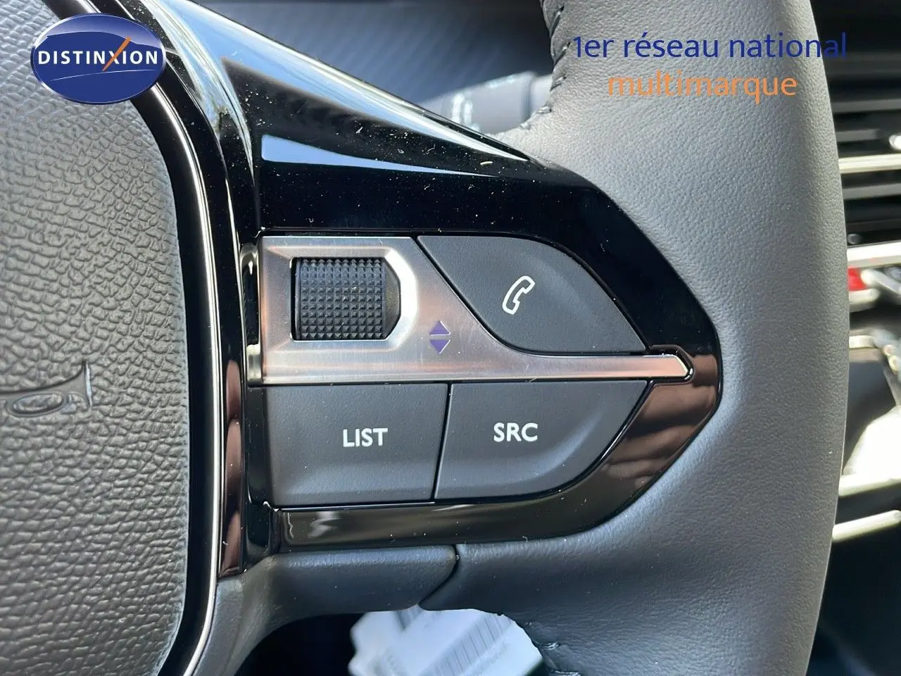 Gros plan sur les commandes au volant du Peugeot 2008 2025, finition Allure, cuir noir et détails noirs brillants.