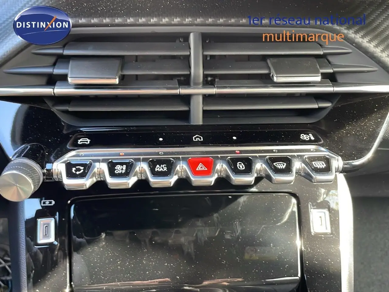 Gros plan sur la console centrale du Peugeot 2008 2025, boutons de commande et aérateurs noirs brillants.