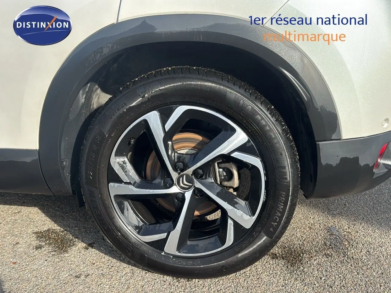 Gros plan sur la roue arrière droite d'un Citroën C5 Aircross blanc nacré avec jante alliage bicolore moderne.