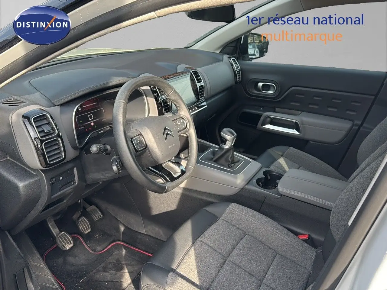 Intérieur du Citroën C5 Aircross blanc nacré 2020, vue côté conducteur, volant, tableau de bord et levier manuel visibles.
