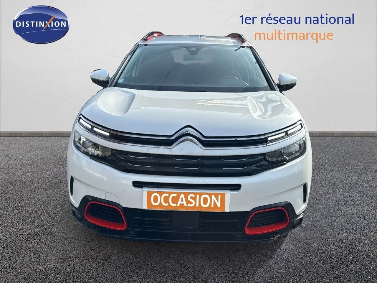 Citroën C5 Aircross blanc nacré en vue frontale, avec détails rouges sur le pare-chocs et calandre noire.
