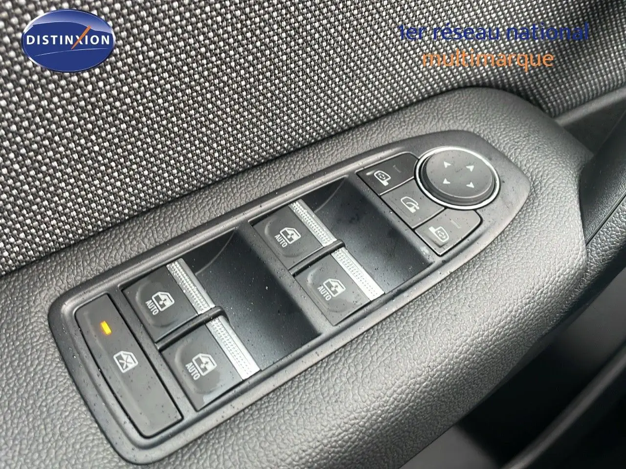 Gros plan sur les commandes des vitres électriques côté conducteur du Renault Captur noir étoile métal avec toit beige.