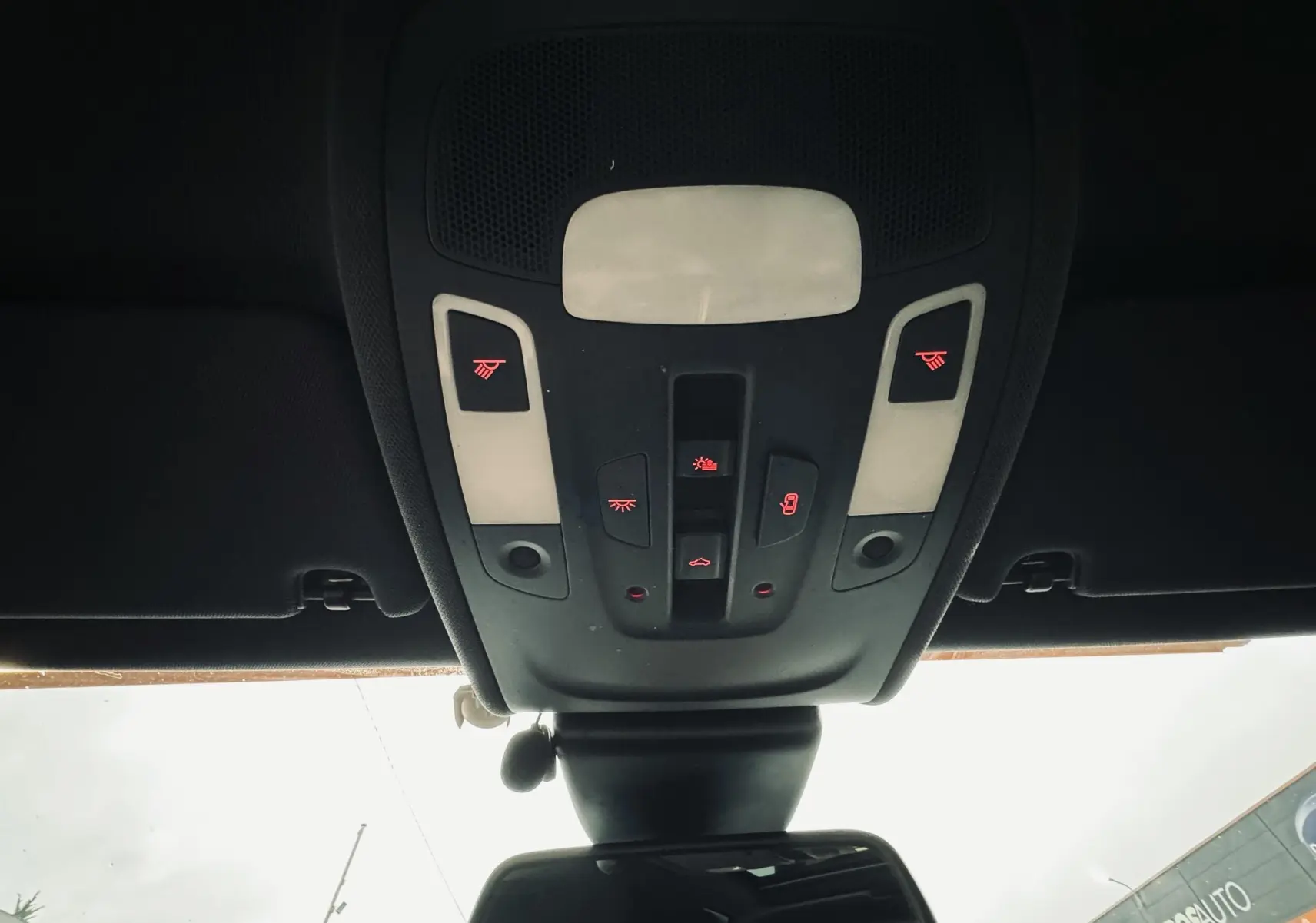 Vue en contre-plongée du plafonnier noir avec commandes lumineuses rouges dans l’habitacle d’une Audi A6 Avant Allroad noire.