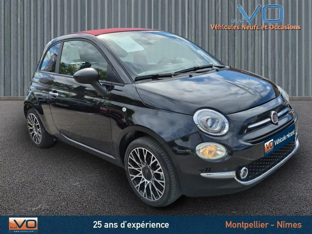 Fiat 500C noire 2024 vue 3/4 avant droit avec toit rouge et jantes alliage, équipée d'une roue de secours visible