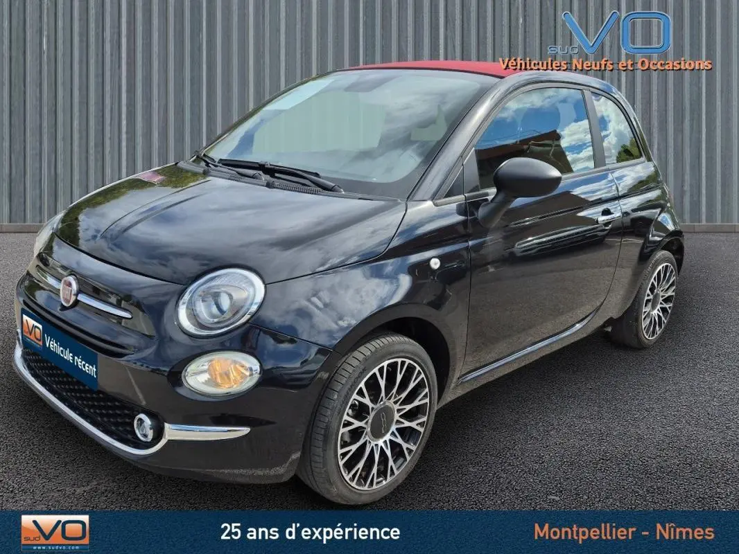 Vue 3/4 avant droite d'une FIAT 500C noire 2024 avec toit rouge et jantes alliage multibranches élégantes.