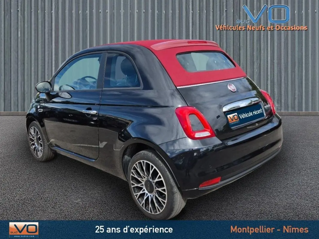 Vue 3/4 arrière droite d'une FIAT 500C noire avec toit rouge, roues alliage et roue de secours visible.