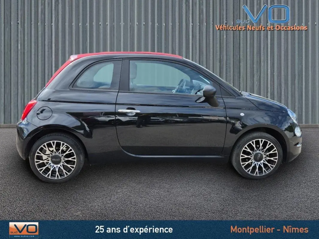 Profil côté gauche d'une FIAT 500C noire 2024 avec toit rouge et roues alliage au design complexe.