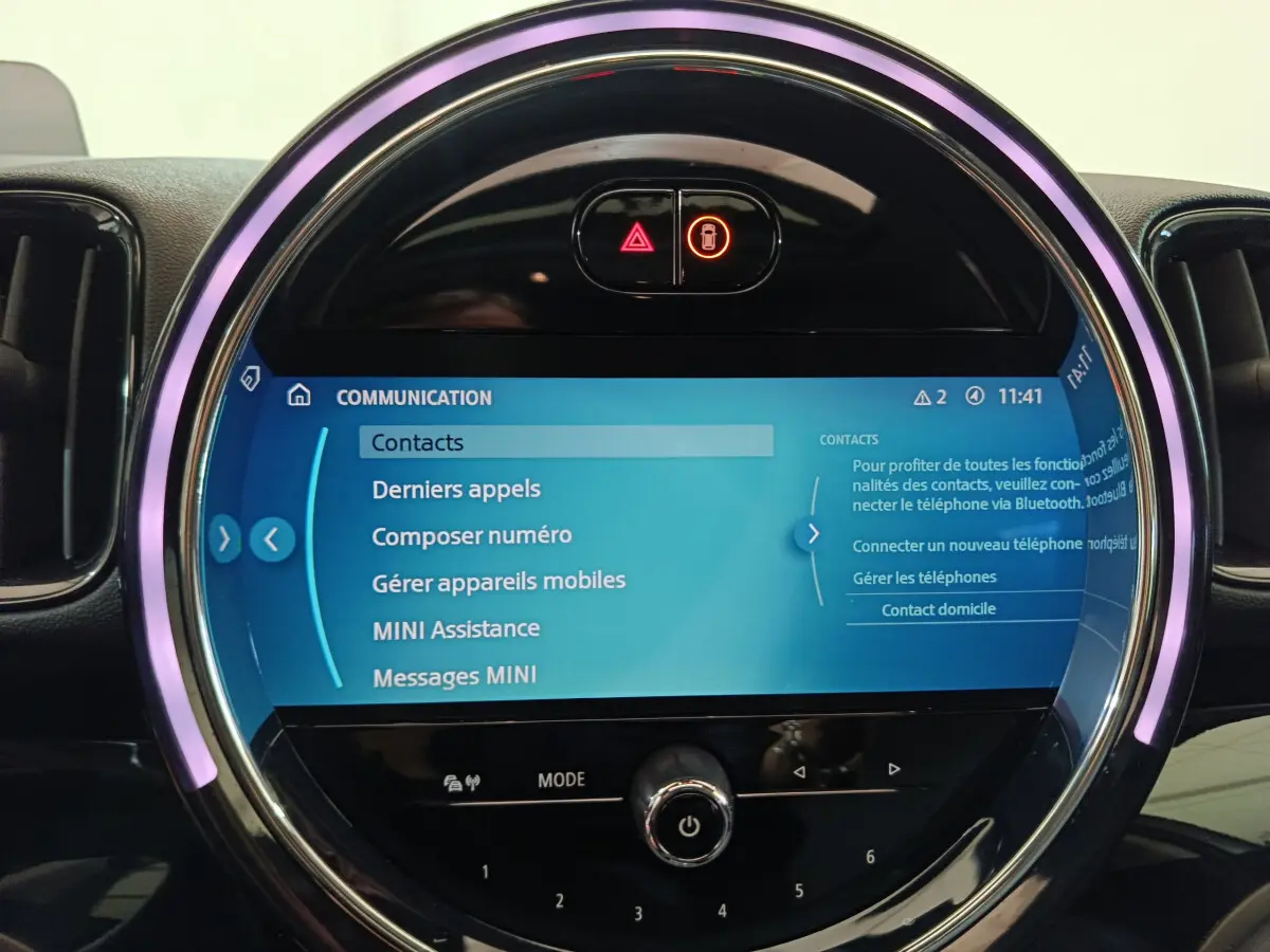 Écran tactile central circulaire du tableau de bord MINI Countryman blanc, avec interface Bluetooth et commandes lumineuses.