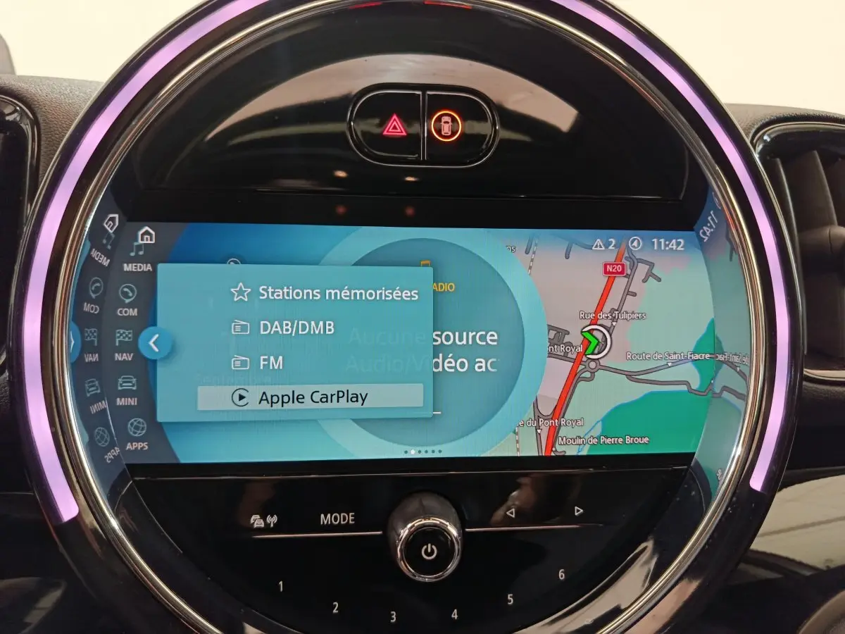 Écran tactile central du MINI Countryman Cooper SE 2021 avec navigation et interface Apple CarPlay, éclairage LED circulaire violet.