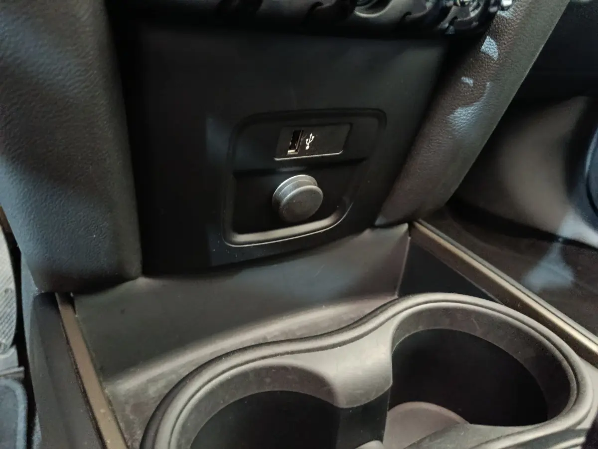 Prise USB et allume-cigare en gros plan dans l'habitacle noir du MINI Countryman Cooper SE 2021.