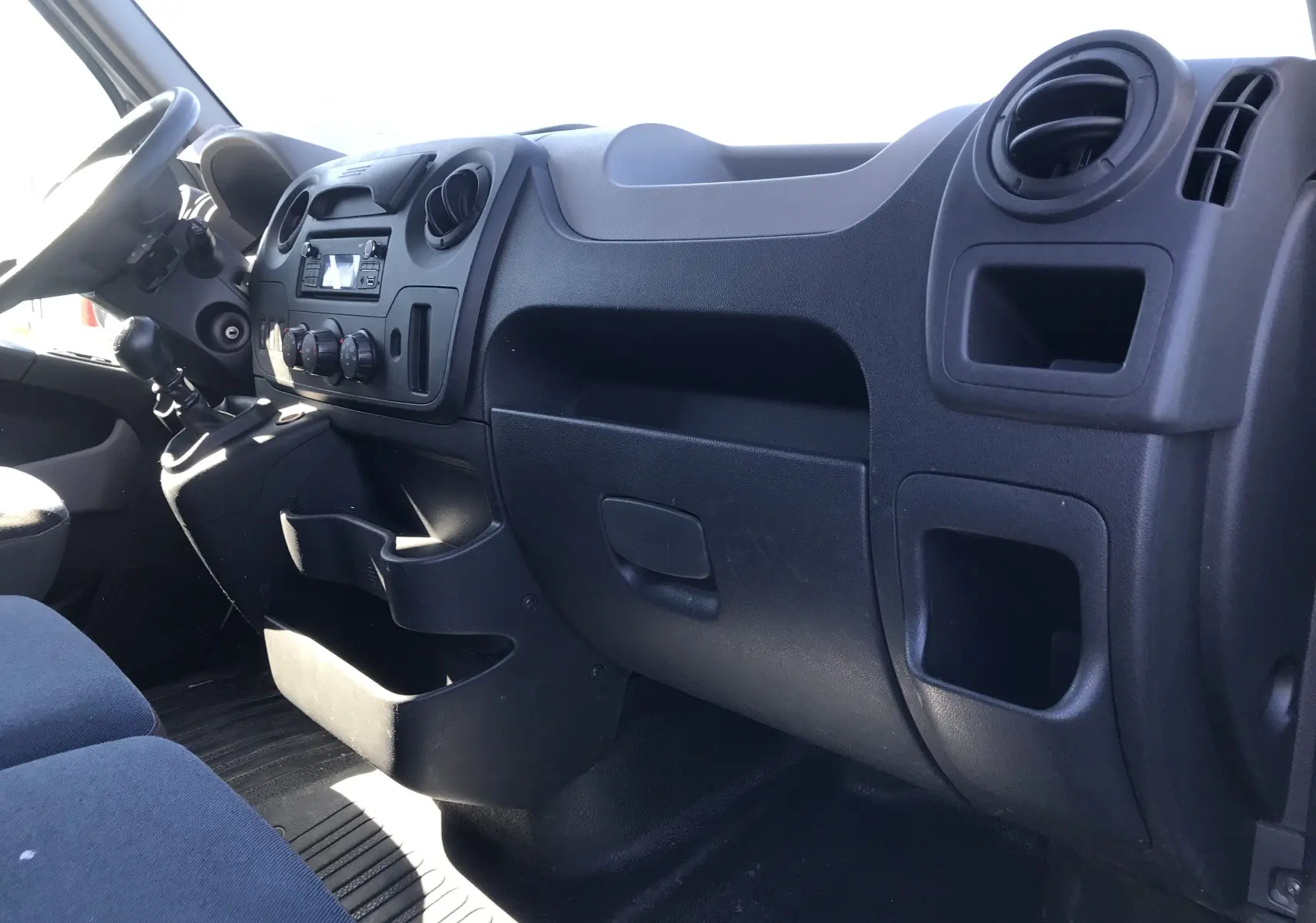 Intérieur du Renault Master 2016, tableau de bord côté passager avec rangements et commandes noires.