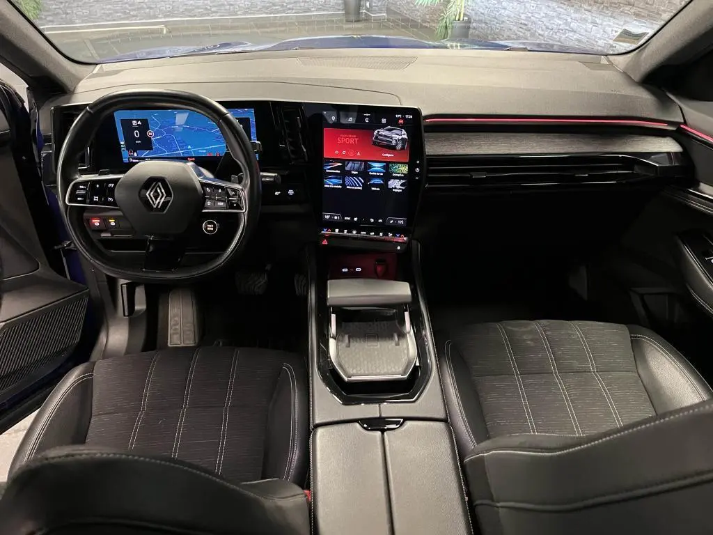 Vue intérieure avant du Renault Austral 2023 bleu, tableau de bord numérique et écran tactile vertical au centre.