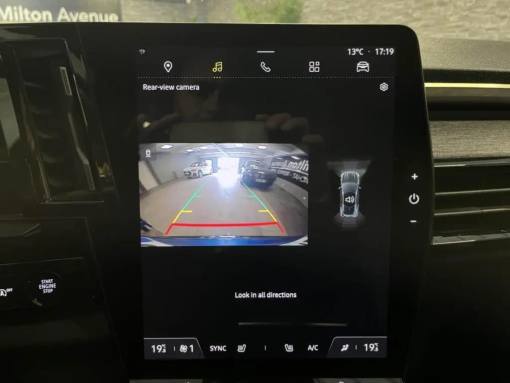 Écran central affichant la caméra de recul du Renault Austral bleu, vue arrière en intérieur de garage.