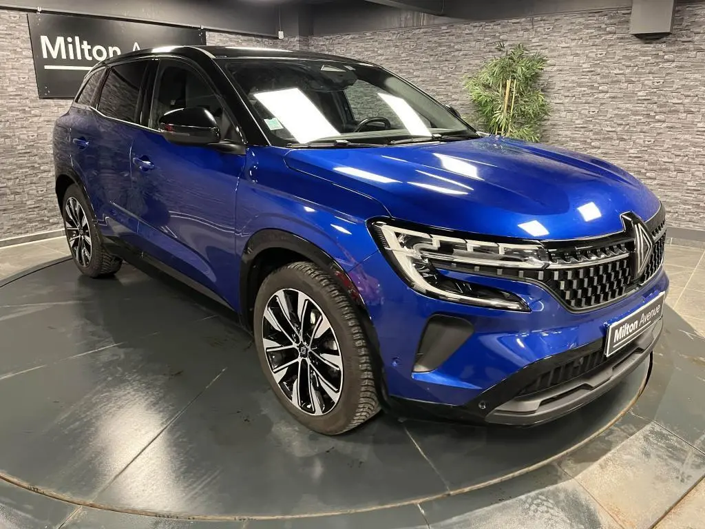 Renault Austral bleu Iron en 3/4 avant droit avec calandre damier chrome sombre et jantes alliage noires diamantées