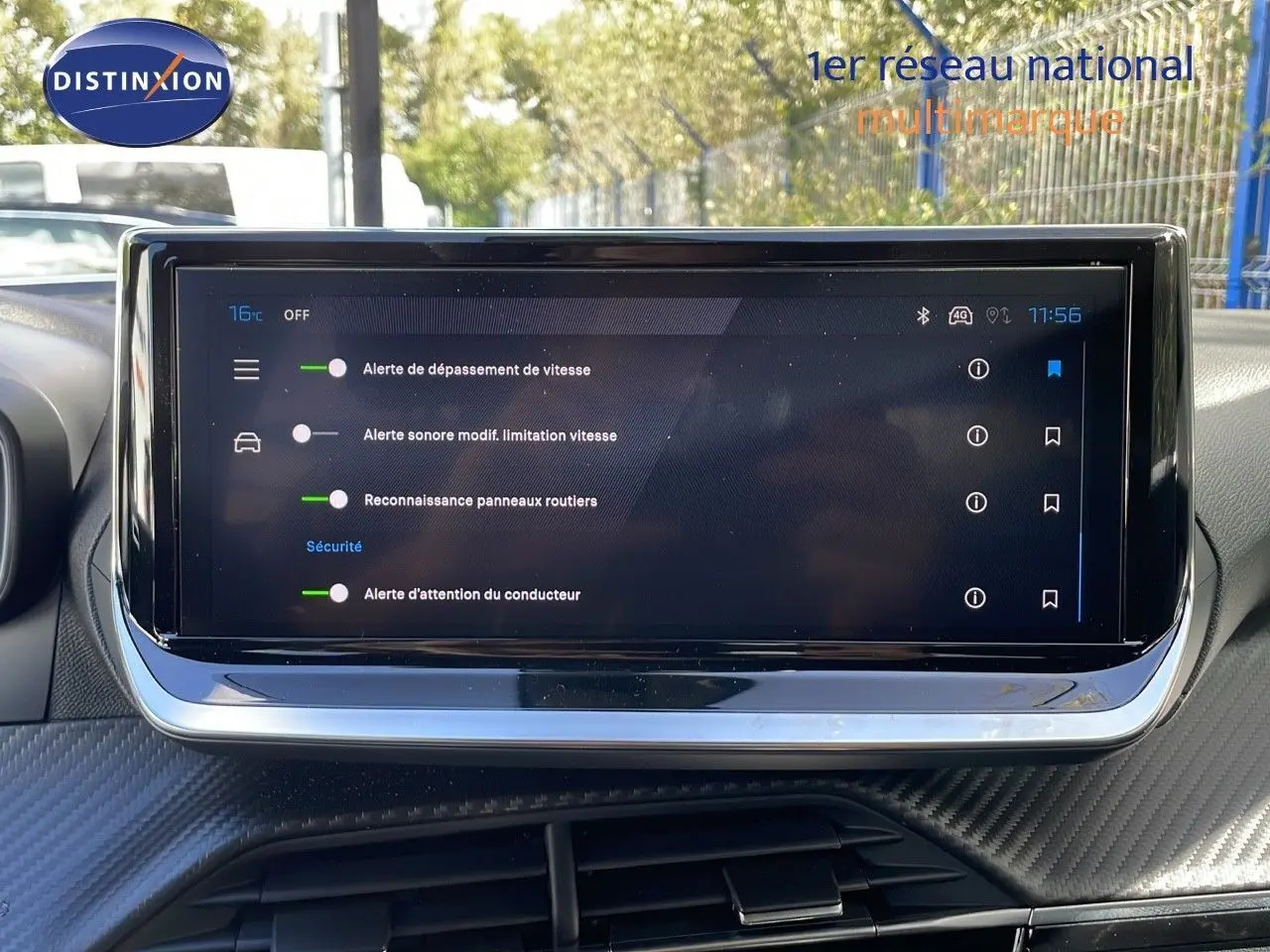 Écran tactile central du tableau de bord du Peugeot 2008 gris, affichant les alertes de sécurité et reconnaissance des panneaux.