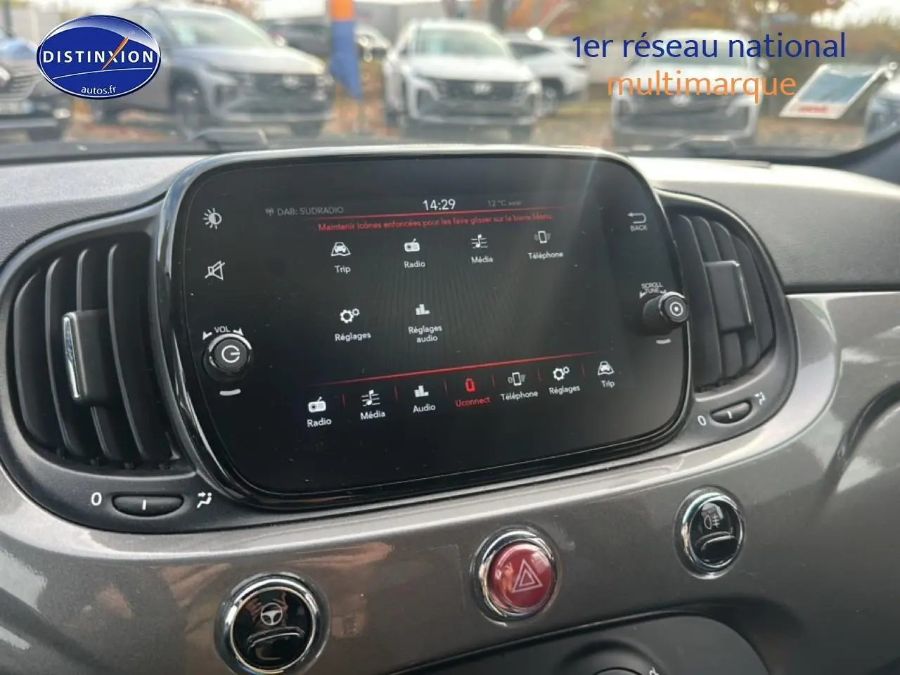 Écran tactile central et commandes du tableau de bord gris d'une Fiat 500 1.0 70 bsg cult vue de face rapprochée.