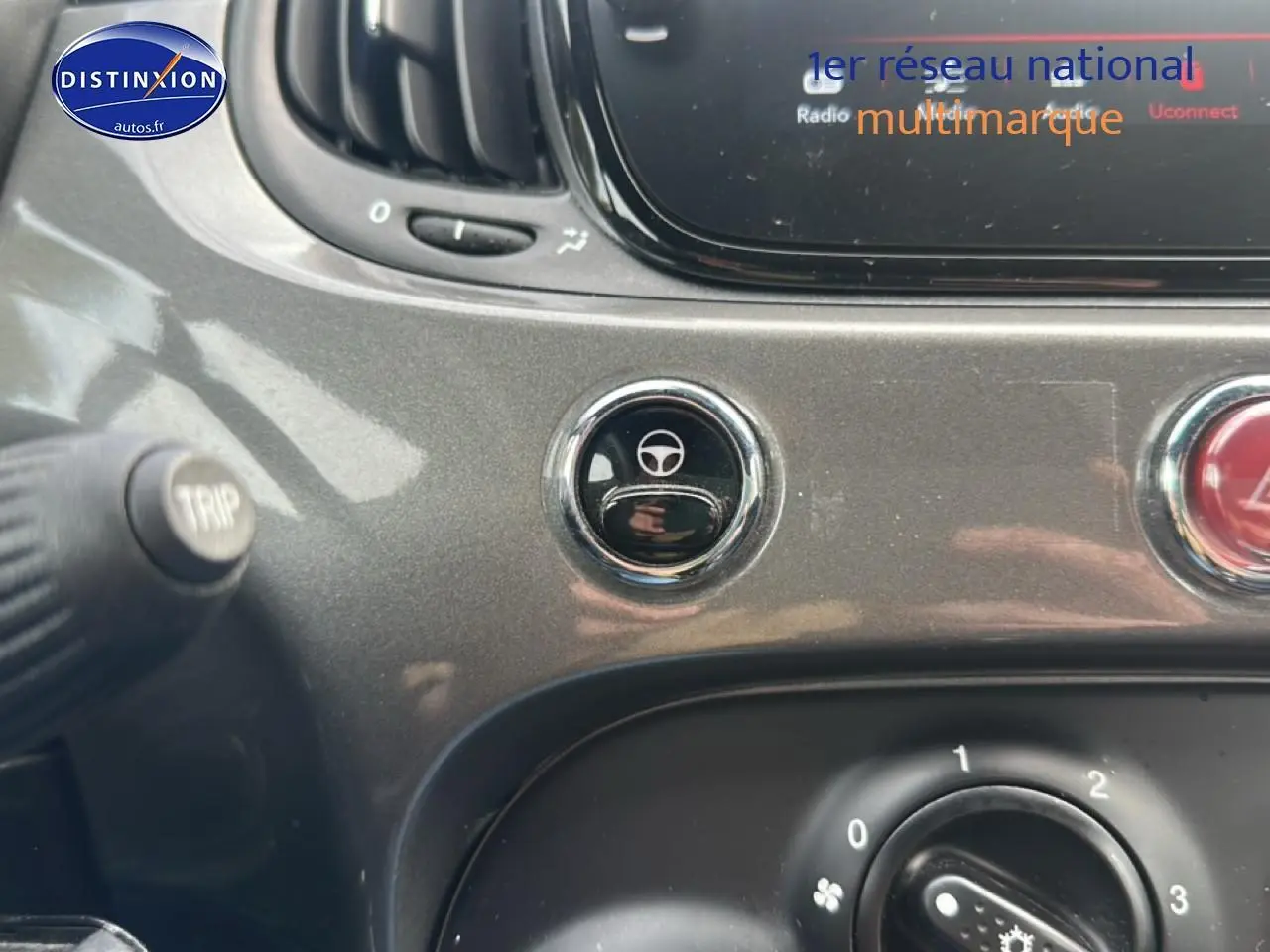 Gros plan sur la console centrale grise de la FIAT 500 1.0 70 bsg cult avec bouton de réglage du volant et commandes climatiques.