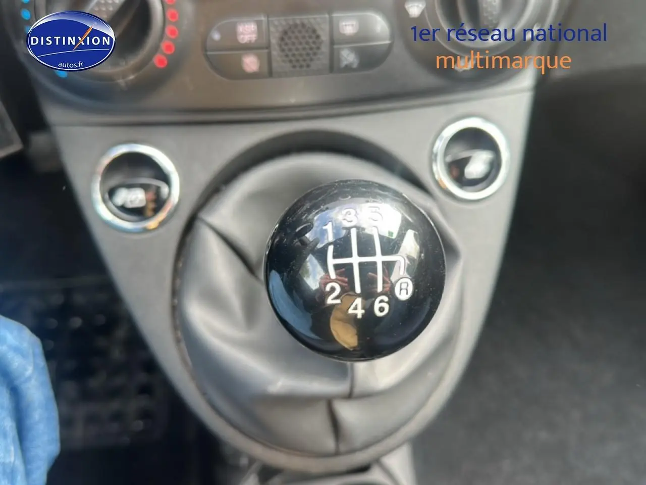Gros plan sur le levier de vitesses manuel noir de la FIAT 500 gris, avec indication des six rapports visibles.