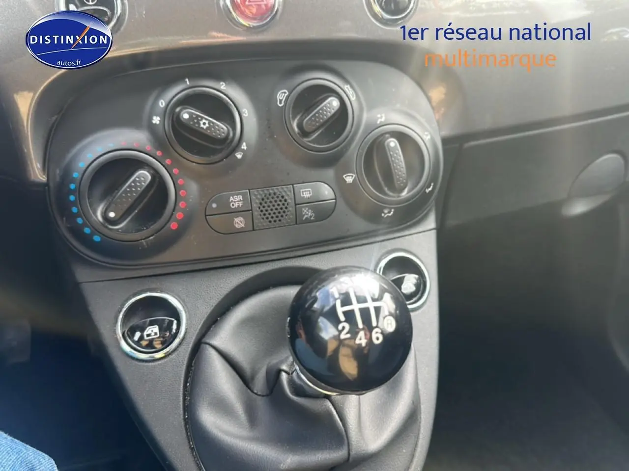 Le levier de vitesse manuel noir de la Fiat 500 gris 1.0 70 bsg cult, avec commandes de climatisation en arrière-plan.