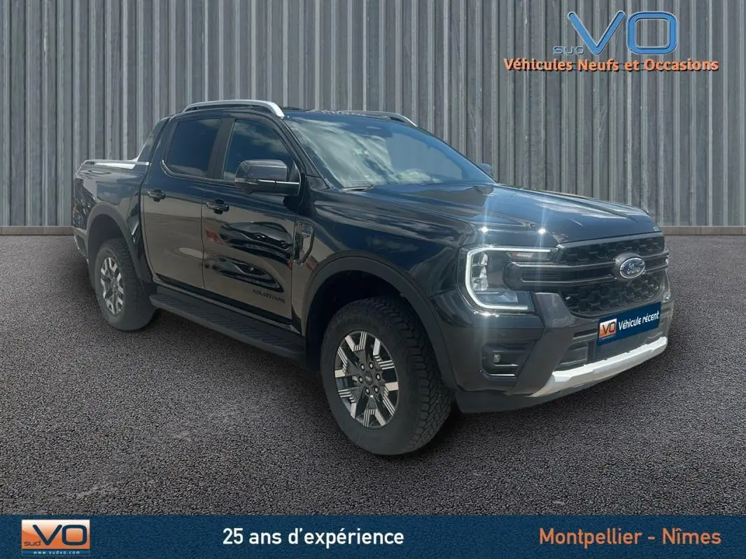 Ford Ranger Wildtrak noir en 3/4 avant droit avec barres de toit, marchepieds et jantes alliage 18 pouces.