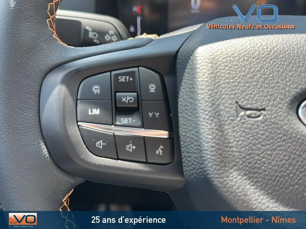 Gros plan sur les commandes multifonctions du volant du Ford Ranger noir 2025 avec réglage de vitesse et volume sonore.