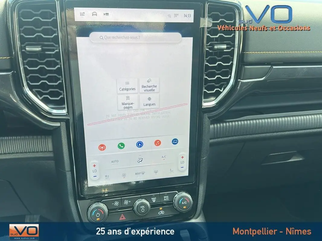 Vue rapprochée de la console centrale tactile du Ford Ranger Wildtrak 2025 noir avec commandes climatisation et ventilation.