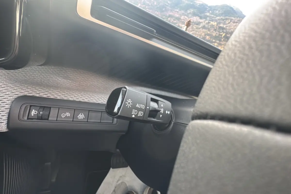Gros plan sur la commande des feux automatique et des aides à la conduite dans l'habitacle d'une Citroën C3 Aircross gris mercury.