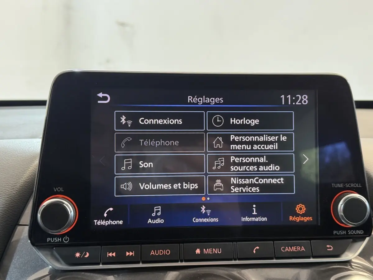 Écran tactile central du tableau de bord du Nissan Juke gris clair, affichant le menu Réglages à 11h28.
