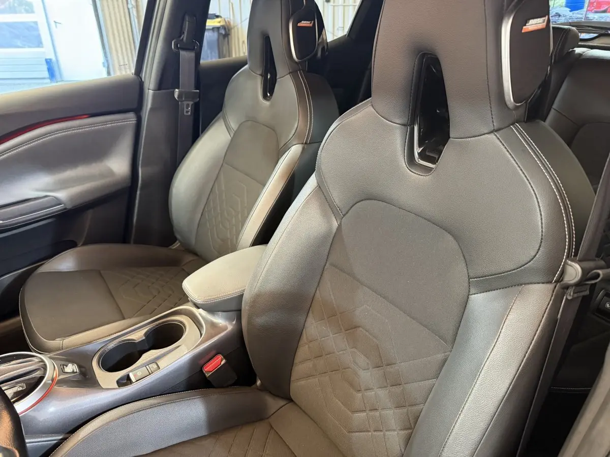 Gros plan sur les sièges avant noirs en cuir et tissu du Nissan Juke Tekna 2021, avec logo Bose visible.