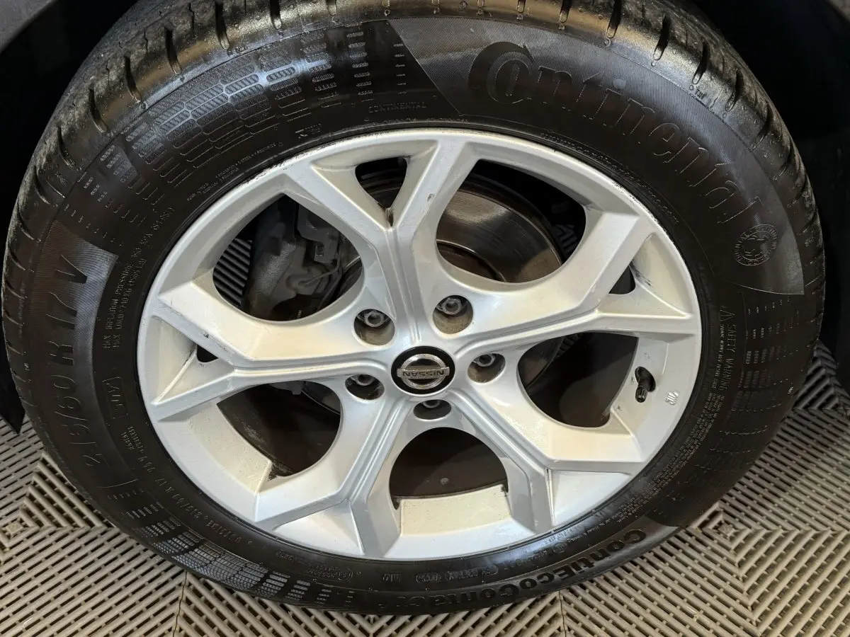 Vue avant d'un Nissan Juke gris clair 2021 avec jantes alliage et phares LED ellipsoïdaux visibles.