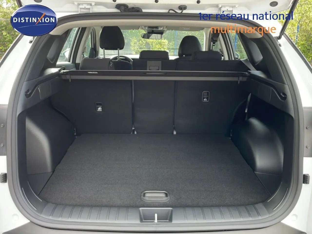 Vue arrière du coffre ouvert du Hyundai Tucson blanc Atlas 2026, montrant un espace de chargement spacieux et bien fini.