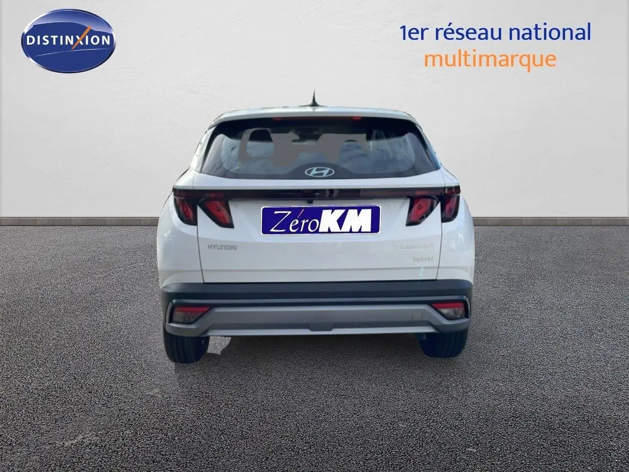 Vue arrière d'un Hyundai Tucson blanc Atlas 2026 avec feux arrière noirs et logo Hyundai visible.