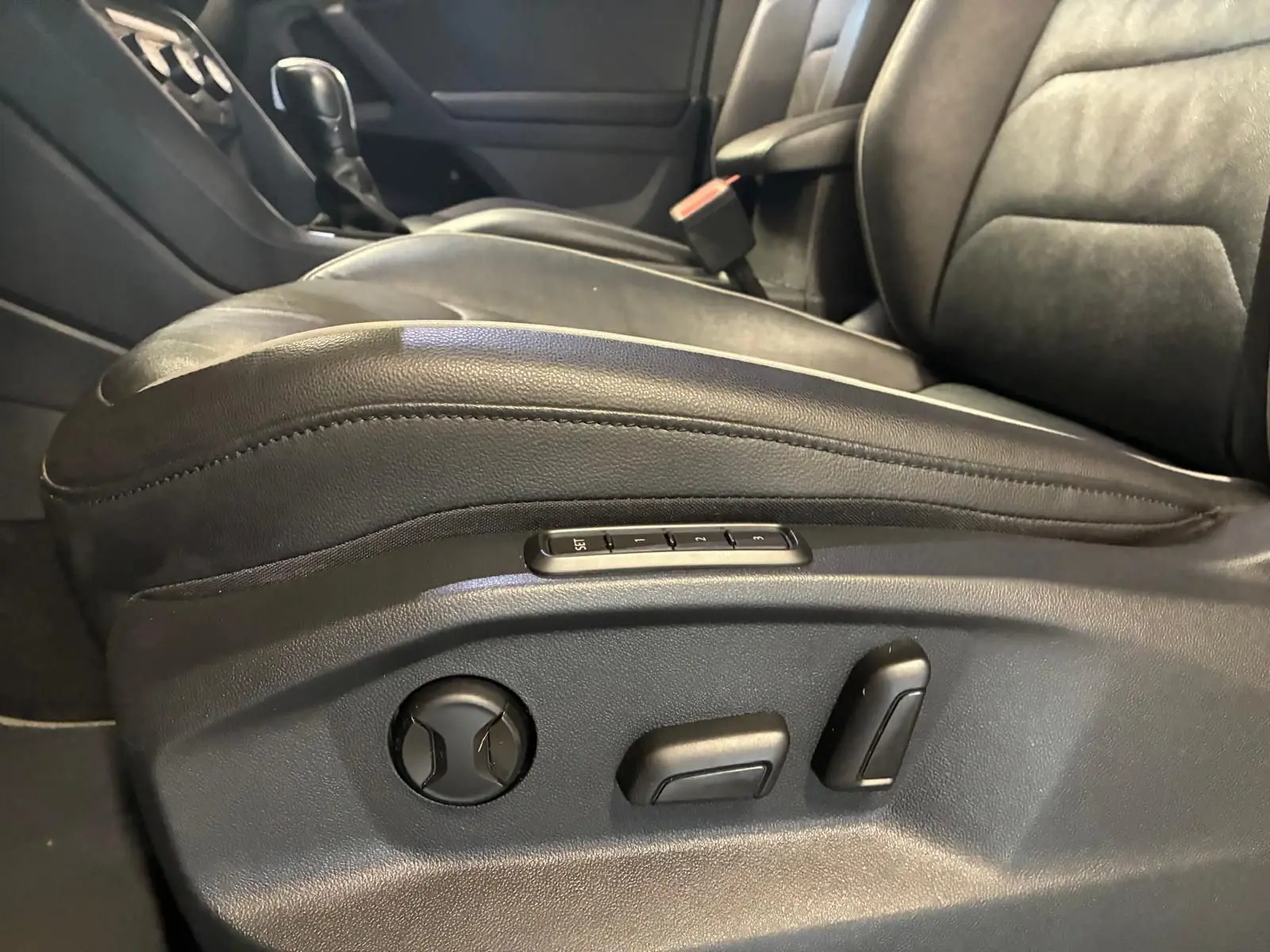 Gros plan sur le siège conducteur en cuir noir d’un Volkswagen Tiguan 2020, avec commandes électriques visibles sur le côté.