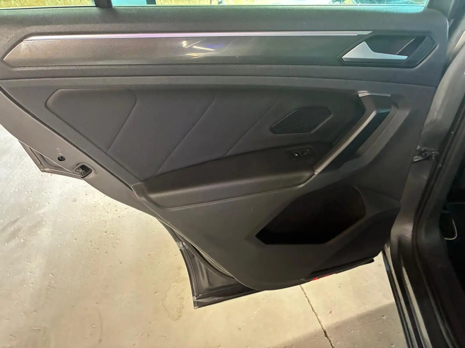 Vue rapprochée de la porte arrière droite gris foncé du Volkswagen Tiguan 2.0 TDI 190 4MOTION Carat Exclusive, intérieur noir.