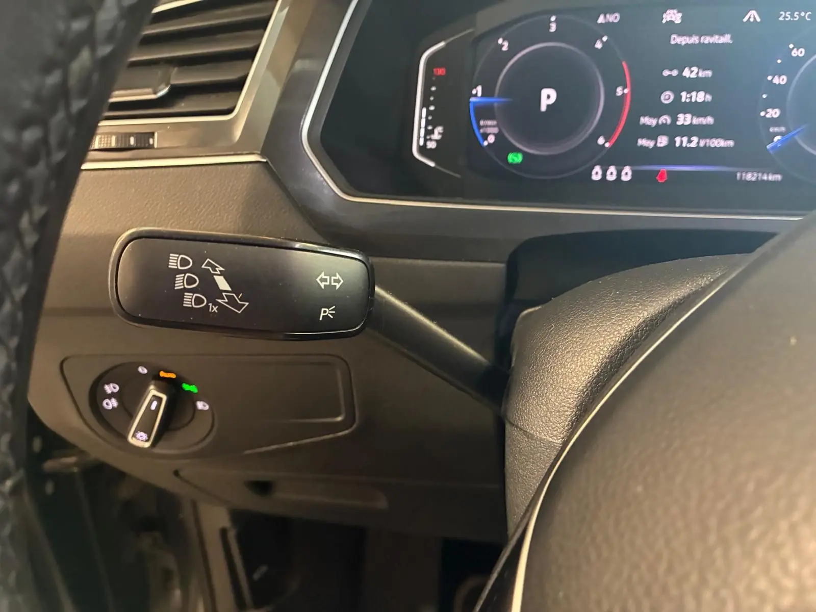 Détail intérieur du Volkswagen Tiguan 2020 montrant le commodo des clignotants et le tableau de bord numérique en arrière-plan.