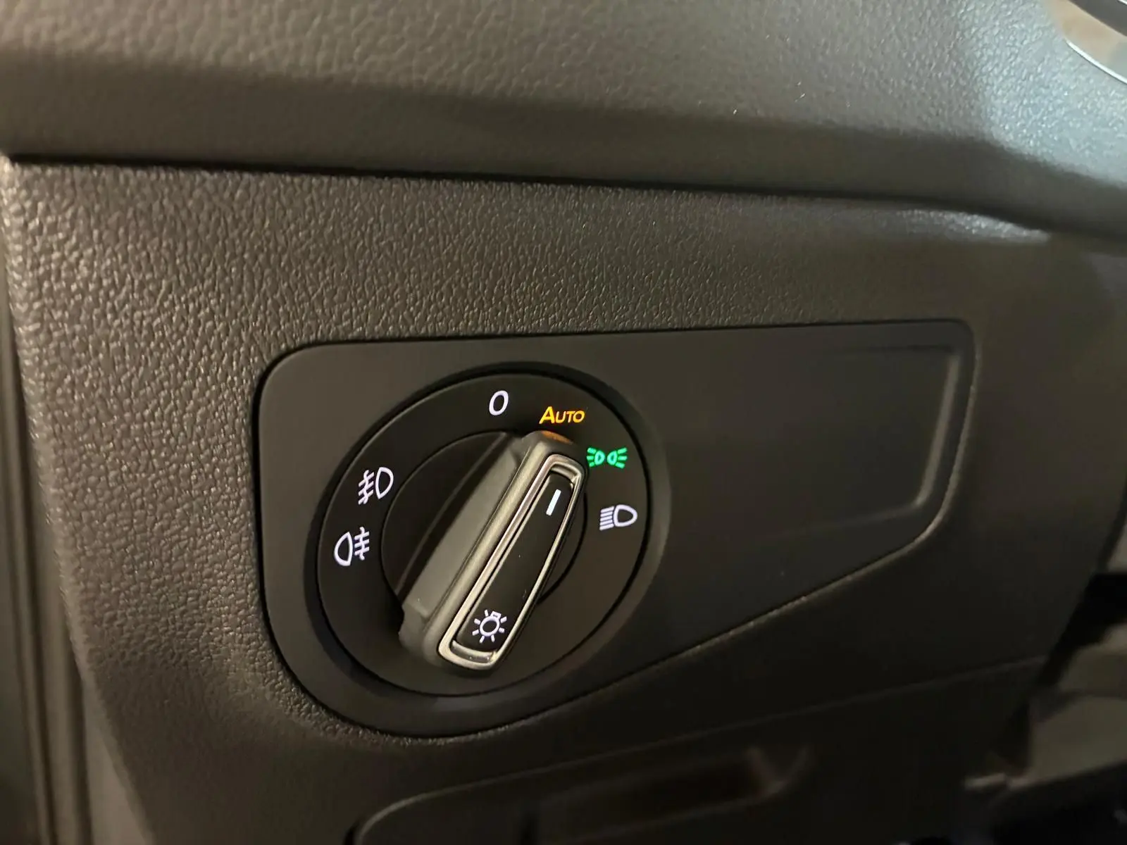 Gros plan sur le bouton de commande des phares du Volkswagen Tiguan 2020, avec éclairage automatique activé.